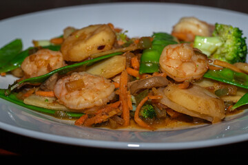 Fototapeta premium Stir fried shrimp and vegetables on a white plate