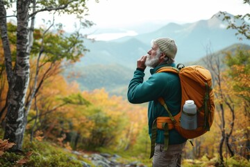 A lone hiker stands amidst the stunning autumn wilderness, his trusty backpack and sturdy outdoor gear ready to conquer the towering mountain ahead