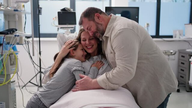 Father and daughter visiting mother in hospital after surgery. Emotional support from family for patients in hospital.