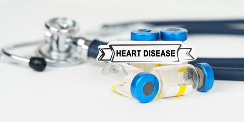 On the table there is a stethoscope, injections and a sign with the inscription - Heart disease