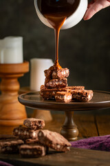 Pouring melted chocolate over brownies.
Bakery, confectionery concept.