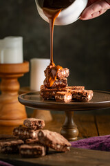 Pouring melted chocolate over brownies.
Bakery, confectionery concept.