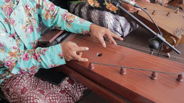 Indonesian people wear traditional clothes (batik) and play the kacapi for an entertainment event in Yogyakarta, Indonesia