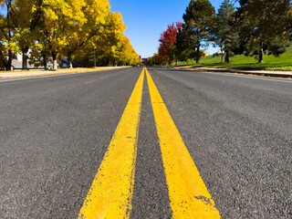 Symmetrical view of yellow road lane lines with diminishing perspective