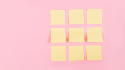 Banner with a clean yellow stickers on a pink background with place for text. Business concept. Tear-off paper for notes, reminders or quick temporary messages, organazer of thoughts and ideas