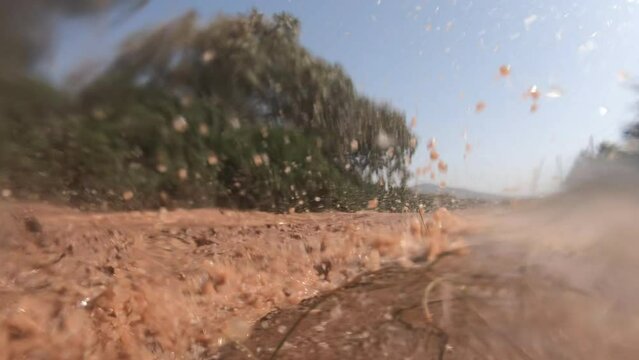 Slow motion view of a dirt bike passing on a puddle