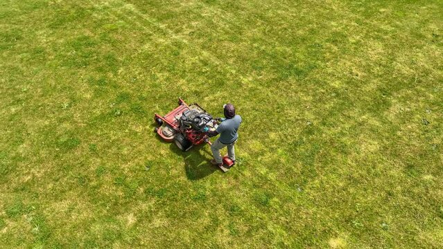 Landscaper mowing the lawn of a modern upscale American home