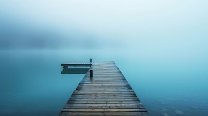 Fototapeta premium lake with wooden pier disappearing into fog