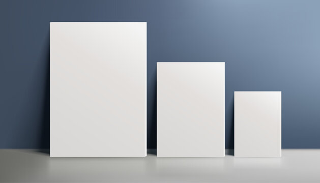 A realistic canvas mockup with blank space, three canvases by the wall on navy blue background, perfect for posters, art projects, paintings, presentations, marketing materials. Not AI.