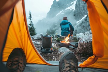 A lone adventurer sits in a cozy tent, surrounded by the rugged beauty of the mountains, their trusty pot and fire keeping them warm as they prepare for their next hiking adventure - obrazy, fototapety, plakaty