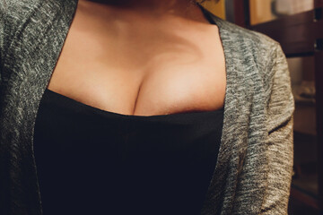 Decollete, female breast. Neckline black dress and fur collar.
