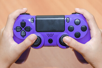 Close up of child hands playing the video game. shot of a child holding a game controller. © lllonajalll