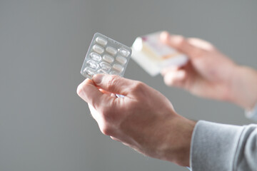 Man hands holding pills in a blister pack