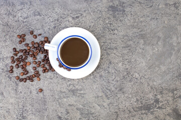Cup of coffee, coffee beans on a concrete background. top view.