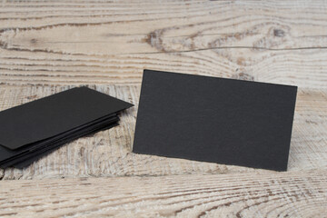 Blank Black business cards on the wooden table. Template for ID. Top view.