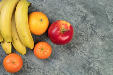 Fruits. Bananas, apples, oranges, tangerines on a biton background.