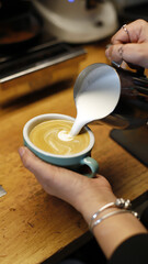 barista preparando un café con leche elaborando una presentación con espuma