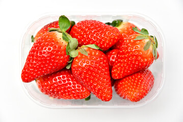 Fresh tasty large strawberries in a tray, top view on a white background.