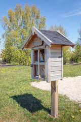 Small wooden, homemade house in the city park using for a library where citizens can take or leave...