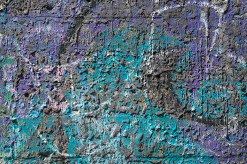 Mixed shades of cyan, black and purple colour dripped paint on old concrete wall background. Natural paintbrush strokes and textured rough cement