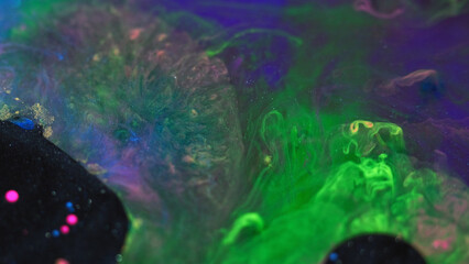 Abstract background. Paint mix bubbles. Stain art. Colorful blue pink glitter black oil ink round blot spreading in green swirls liquid in hypnotic creative design.