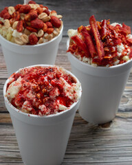 group of Mexican snacks, several corns in cups,trolelote, prepared with chili, peanuts, chips, chamoy sauce, delicious