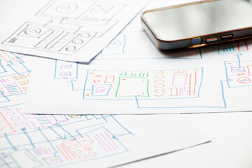 Development and sketches on paper of a custom mobile application on the desktop, graphic design