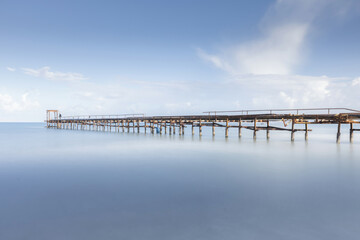 Fototapeta na wymiar Awesome calming long exposure landscape of ruined pier rusted. long exposure seascape 