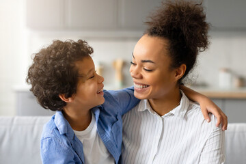 Joyful black mother and son share tender moment and embracing at home