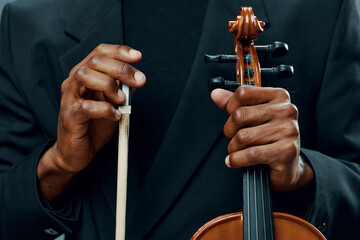 Close up of hands holding the bow of a violin, capturing the delicate touch and artistry of playing music