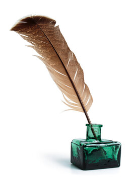 Quill pen with a glass bottle of ink. Feather in a green vintage inkwell