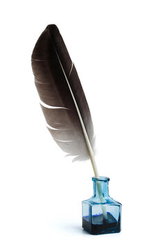 Feather with a glass bottle of ink. Feather in a blue vintage inkwell