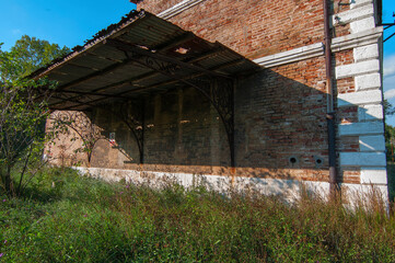 Lato di facciata in mattoni di un antico edificio in stato di abbandono