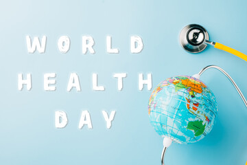 World Health Day Concept. Top view yellow doctor stethoscope and world globe isolated on pastel...