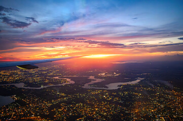 Vista da janela de avião comercial do Rio Iguaçu e Rio Paraná durante voo noturno com luzes da...