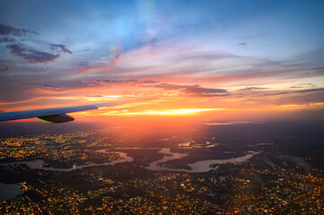 Vista da janela de avião comercial do Rio Iguaçu e Rio Paraná durante voo noturno com luzes da...
