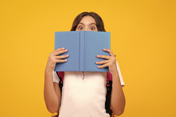 School teenage girl with school bag backpack hold book on yellow isolated studio background....