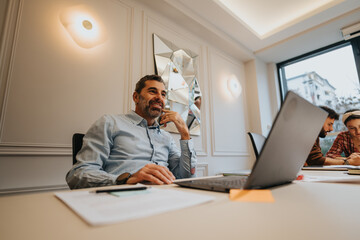 Engaged and happy male professional enjoying a light moment during a business meeting. Colleagues...