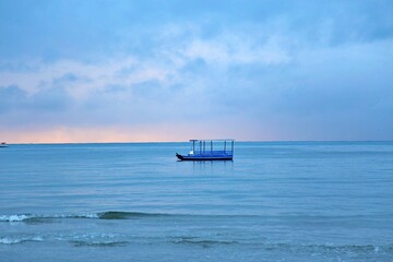 fishing boat parked on coastine, blue sunrise with first sun light of day. Japaratinga, Alagoas, Brazil. 