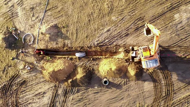 Drone footage of laying underground power line in the middle of the field during autumn morning