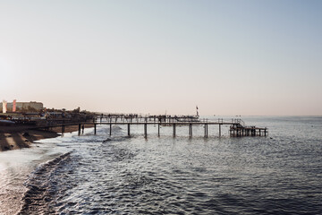 Fototapeta premium Mediterranean Sea, sandy beach with pebbles and palm trees. relaxation area with sun loungers by the sea.Turkey