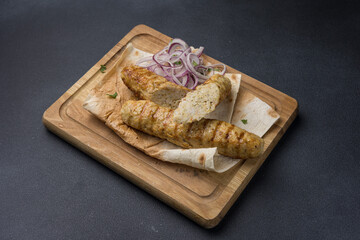 Delicious Lyulya kebab on a wooden board. Close-up 