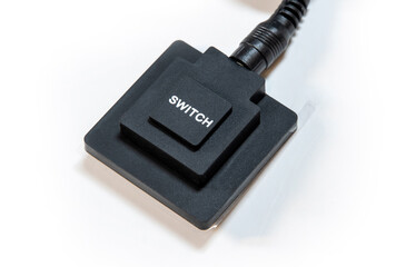 Simple generic black push button switch with the word SWITCH printed on top, object white background, cut out, nobody. Turning devices on and off, electronics control abstract concept, technology