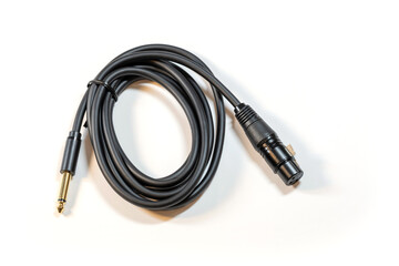 Coiled black audio cable featuring a 1/4 inch jack on one end and an XLR male connector on the other, isolated on white background, nobody. Professional mic microphone studio cable object, nobody