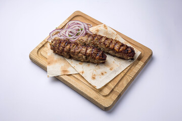 Delicious Lyulya kebab on a wooden board. Close-up 