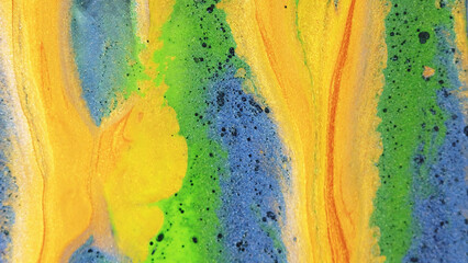 Abstract background. Glitter dye. Shiny liquid mix. Vivid yellow green blue black color ink shimmering particles grain texture paint drop wave spreading.