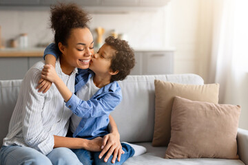 Preteen black son giving his mother loving kiss on the cheek - obrazy, fototapety, plakaty