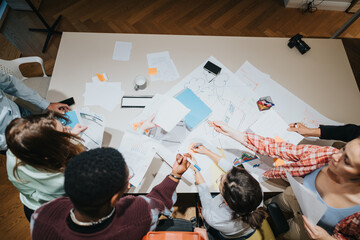Overhead view of a multigenerational business team actively engaged in a collaborative meeting,...