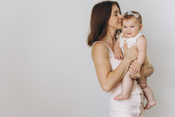 Happy young mother with her adorable baby girl on white background