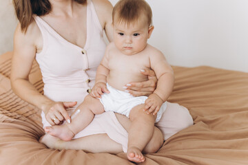 Fototapeta na wymiar Happy mother applying cream on her baby girl's body